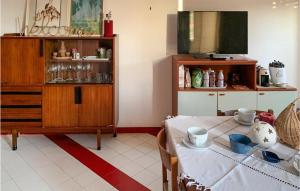 un salon avec une table et une télévision dans l'établissement Cozy Apartment In Donnalucata With Kitchen, à Donnalucata