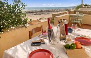 - une table avec des verres à vin et une vue sur la plage dans l'établissement Cozy Apartment In Donnalucata With Kitchen, à Donnalucata