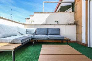 a couch on a balcony with green grass at atico reformado con terraza en lavapies in Madrid