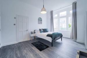 a white bedroom with a bed and a window at (S4) Beautiful Studio Close To a Tube Station in Harrow on the Hill