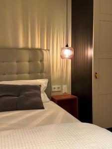 ein Schlafzimmer mit einem weißen Bett und einer Lampe in der Unterkunft Fidschis Apartment Nr 3 in Nürtingen