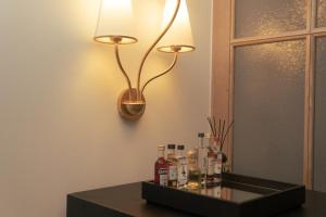 Magda Boutique Rooms في لندن: مصباح على طاولة مع زجاجات عليه