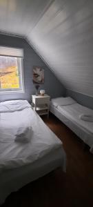 a bedroom with two beds and a window at Jøssingfjord Apartments in Sokndal