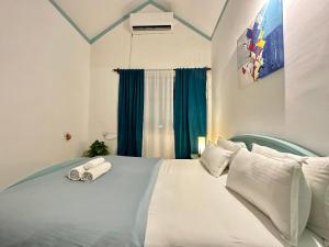 białe łóżko z dwoma składanymi ręcznikami na górze w obiekcie Villa By The Beach Goa w mieście Benaulim
