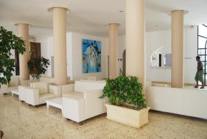 un hall avec colonnes, meubles blancs et plantes dans l'établissement Hotel El Andalous, à Soliman