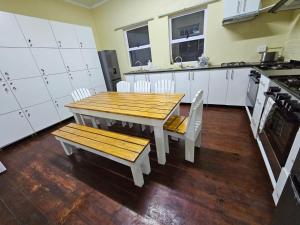 uma cozinha com uma mesa de madeira e cadeiras em 11 on Elizabeth em Mount Road