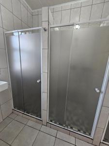 uma cabina de duche com uma porta de vidro na casa de banho em 11 on Elizabeth em Mount Road
