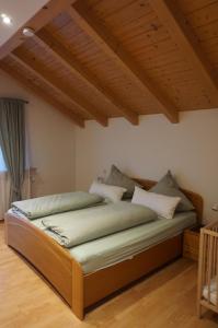 a large bed in a room with wooden ceilings at Ferienwohnung im Brechstubenweg in Kiefersfelden