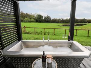 um lavatório com duas garrafas e dois copos numa mesa em Dragonfly Shepherd's Hut em Aberaeron