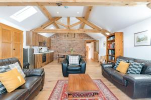 a living room with leather couches and a table at ryton grange church barn sleeps 5 in Shrewsbury
