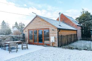 a small cabin with a table and a fence at ryton grange church barn sleeps 5 in Shrewsbury