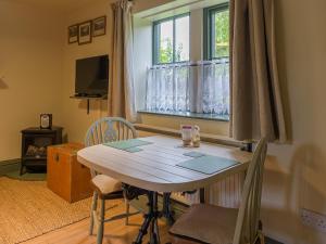 a dining room with a table and a window at Pail End in Brassington