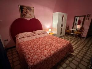 - une chambre avec un lit à tête rouge dans l'établissement Corte De Ritis, à Giovinazzo