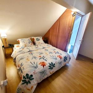 ein Schlafzimmer mit einem Bett mit einer Bettdecke darauf in der Unterkunft Appart Angel in Saint-Benoît
