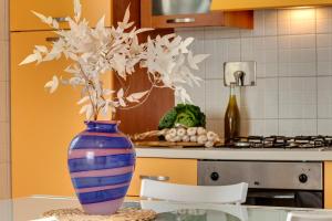 un jarrón azul con flores blancas sobre una mesa en una cocina en A casa di Anna en San Miniato