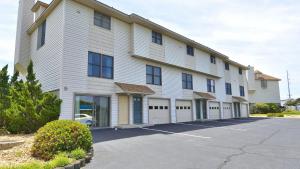 キティホークにあるOceanside, Close to Beach Access, Community Pool, KHSDD1, Sea Dunes D1の駐車場付きの白い大きな建物