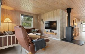 a living room with a chair and a fireplace at Beautiful Home In lbk With 3 Bedrooms And Wifi in Ålbæk