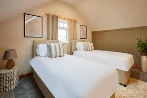 two white beds in a room with a window at Host & Stay - Fawcett Cottage in Tollerton
