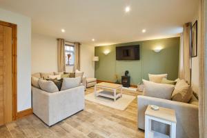 a living room with two couches and a table at Host & Stay - Fawcett Cottage in Tollerton