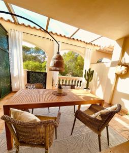 ein Esszimmer mit einem Holztisch und Stühlen in der Unterkunft Can Somni - Appartement bohème, zen et chic avec piscine in Cala Figuera