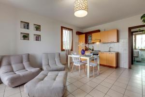 sala de estar con 2 sofás, mesa y cocina en A casa di Anna en San Miniato