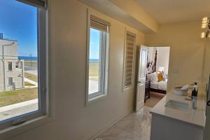 een badkamer met een wastafel en een raam met uitzicht op de oceaan bij Lakehouse with Rooftop View in Bowmanville