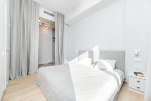 biała sypialnia z białym łóżkiem i białymi zasłonami w obiekcie Brand new 2bdroom Free Parking Apartment w Tallinnie