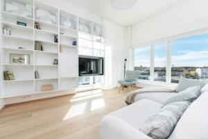 salon z białymi meblami i dużym oknem w obiekcie Brand new 2bdroom Free Parking Apartment w Tallinnie