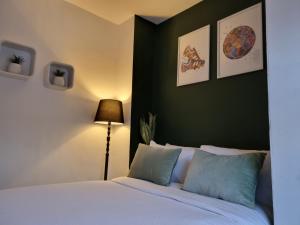 a bedroom with a white bed and a green wall at Charming and cosy home near LFC Stadium, 10 mins drive to the Liverpool city centre in Liverpool
