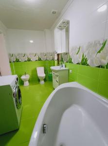 a green bathroom with a tub and a toilet at Villa Zgarda1 in Mykulychyn