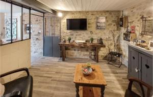 cocina con mesa y TV en la pared en Nice Home In Frossay With Kitchen, en Frossay