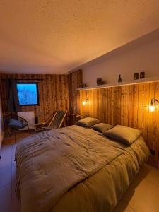 - un grand lit dans une chambre dotée de murs en bois dans l'établissement Le repère de Bianca, le premier de cordée, à Montgenèvre