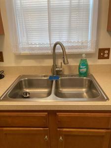 a stainless steel kitchen sink with a soap bottle on it at Midtown Harrisburg Townhouse in Harrisburg