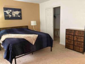 a bedroom with a blue bed and a dresser at Midtown Harrisburg Townhouse in Harrisburg