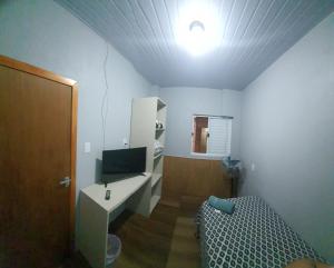 Habitación con cama y TV. en Hotel Majestic, en Pelotas