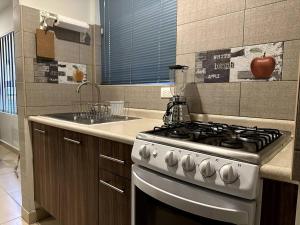 a kitchen with a stove and a counter top at Dpto agradable cerca del Aeropuerto y Foro Sol in Mexico City