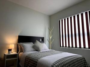 a bedroom with a bed and a large window at Dpto agradable cerca del Aeropuerto y Foro Sol in Mexico City
