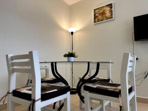 a dining room table with two chairs and a lamp at Dpto agradable cerca del Aeropuerto y Foro Sol in Mexico City