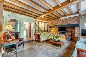 - un salon avec une cheminée en briques et un canapé dans l'établissement Perry Farm by Bloom Stays, à Canterbury