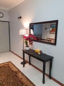 een kamer met een tafel en een spiegel aan de muur bij Sri Lagenda Apartment Langkawi in Kuah