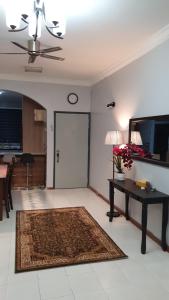 een woonkamer met een tafel en een deur met een klok bij Sri Lagenda Apartment Langkawi in Kuah