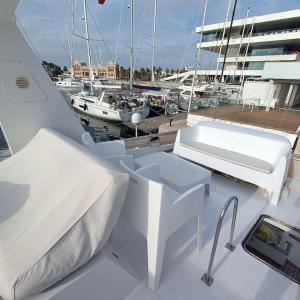 Un bote blanco con una cama y una tablet. en Ciudad y playa desde un barco., en Valencia