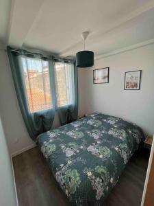 a bedroom with a bed and two windows at Appartement en plein cœur du centre ville in Les Sables-d'Olonne