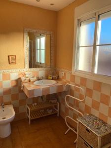 uma casa de banho com um lavatório, um WC e um espelho. em Familia Anfitriona acoge terraza em Sevilha