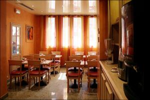 une salle à manger avec des tables et des chaises ainsi qu'une fenêtre dans l'établissement Grand Hotel Dore, à Paris