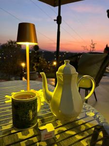 una tetera y una taza sobre una mesa con una lámpara en The Cypress Villa & Vineyard II, en Sremska Kamenica