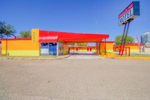 een felgekleurd tankstation met een bord aan de voorkant bij Wheeler Inn Texas, US - 83 By OYO in Wheeler