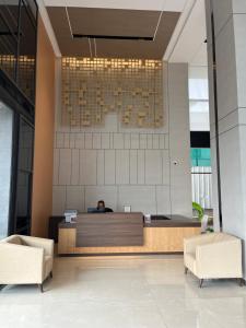 a lobby with a reception desk and two chairs at PRESIDENCY AIRPORT HOTEL in Cochin +37 photos