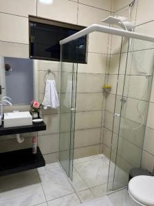 uma casa de banho com uma cabina de duche em vidro e um WC. em Linda casa completa confortável em Foz do Iguaçu