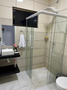 Un baño con ducha de cristal y un inodoro. en Linda casa completa confortável, en Foz do Iguaçu